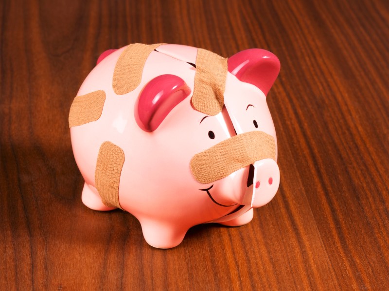 Cracked piggy bank with band aid